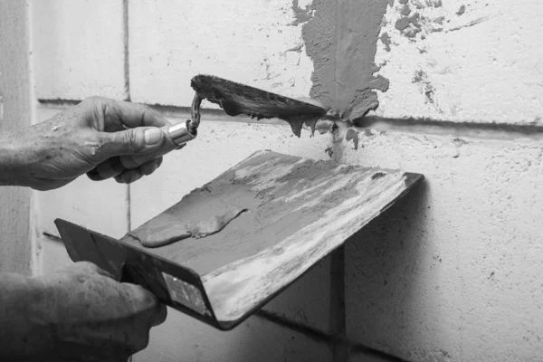 Hábil velhote estucador rebocando cimento no tijolo velho — Fotografia de Stock