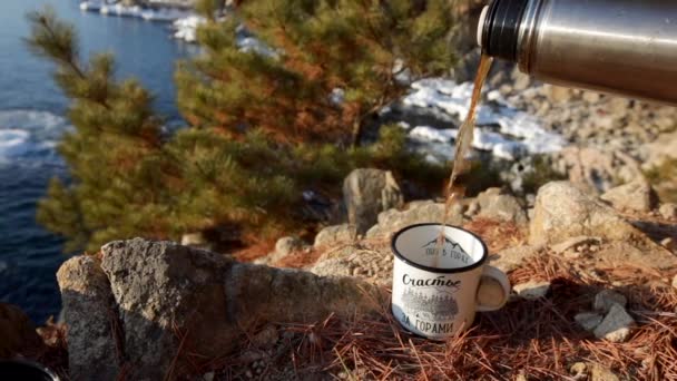 慢动作射击 游客将热茶倒入白色金属杯 对岩石和预留海 — 图库视频影像
