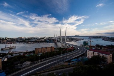 Altın Askılı köprü yol araç trafiği yukarıdan. Modern Vladivostok Rusya gece aydınlatma. Eski ve modern Merkez binaları.