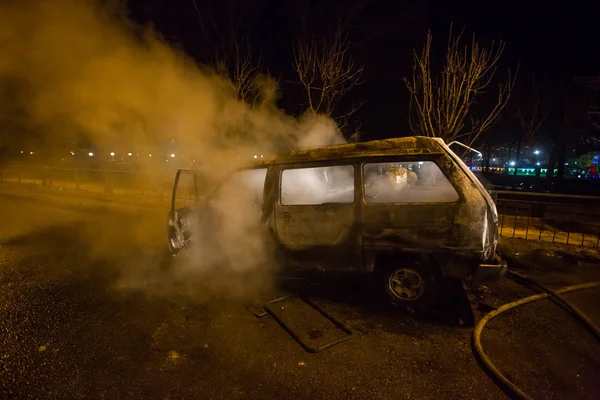 Employees of the Ministry of Emergency Situations of Russia extinguish a burned-out car - a minibus at night
