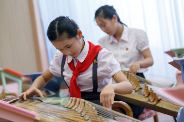 Temmuz, 2018, Pyongyang, Kuzey Kore - Pyongyang pioneer ev öğrenciler şarkı, çizim ve geleneksel müzik aletleri çalma içinde nişanlandık