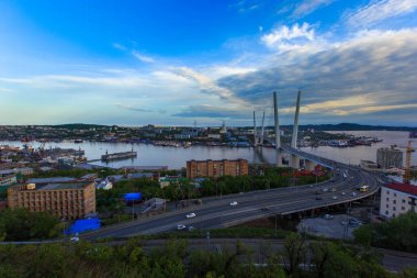 Altın Askılı köprü yol araç trafiği yukarıdan. Modern Vladivostok Rusya gece aydınlatma. Eski ve modern Merkez binaları.