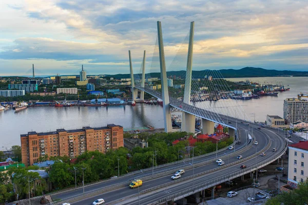 Altın Askılı köprü yol araç trafiği yukarıdan. Modern Vladivostok Rusya gece aydınlatma. Eski ve modern Merkez binaları.