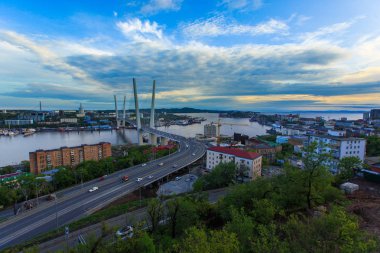 Altın Askılı köprü yol araç trafiği yukarıdan. Modern Vladivostok Rusya gece aydınlatma. Eski ve modern Merkez binaları.