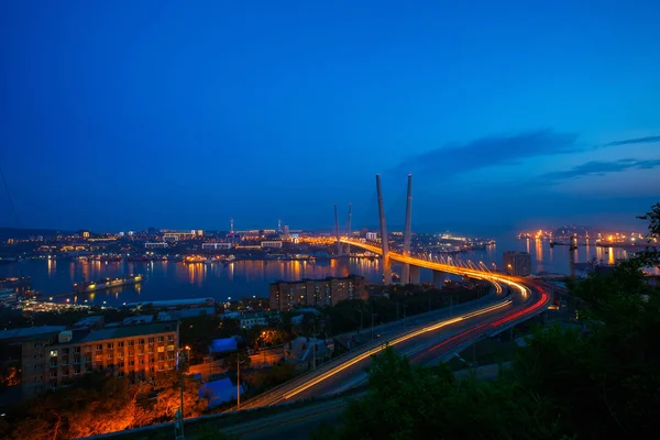从上面的金色的斜拉桥道路汽车交通 现代俄罗斯符拉迪沃斯托克 海参崴 夜间照明 古老和现代的中央大厦 — 图库照片