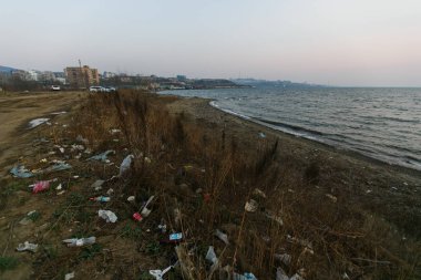 Deniz sahilinde çöp yığınları. Bölgenin kirlenmesi. Sahilde çöplük.