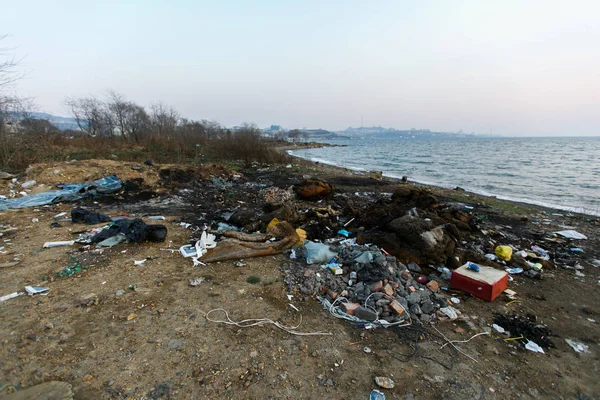 Garbage heaps on the sea beach. Pollution of the territory. Garbage dump on the beach.