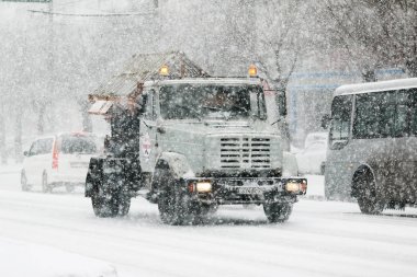 Aralık, 2014 - Vladivostok, Primorsky Krai - Şehrin bir yardımcı kamyon şehir yollarda sürücüler ve bir kar yağışı sırasında reaktifler dağıtır.