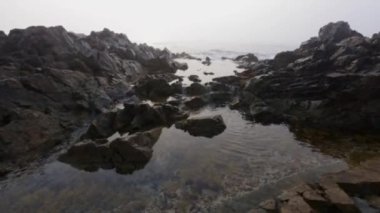 Deniz dalgaları hava sırasında taş üzerinde rulo