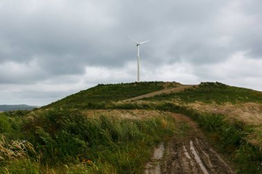 Güzel bulutlar ile mavi bir gökyüzüne karşı bir tepeüzerinde büyük beyaz yel değirmeni