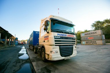 Yaz, 2014 - Vladivostok, Rusya - Vladivostok konteyner terminali sınırları. Ağır yük kamyonu bir konteyner ile bir liman üzerinden seyahat.