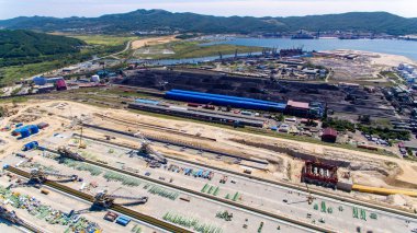 Kömür yığınları ve bir geri talep ile kömür terminali topraklarının havadan görünümü. Kömür terminali altında şantiye.