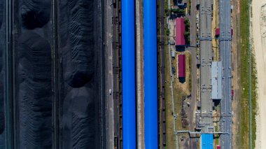 Havadan görünüm. Kömür yığınları ve bir geri talep ile kömür terminali topraklarının. Kömür limanının toprakları.