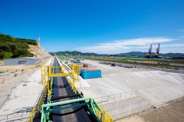 Deniz kömür terminalinin arazisi. Bir kömür terminalinin şantiyesi. Deniz kıyısında yapı malzemeleri ile depo.