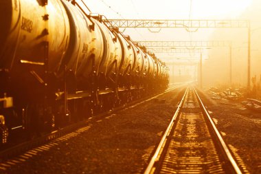 Güzel manzara. Altın gün batımında rayların üzerinde petrol dolu bir demiryolu tankı duruyor..