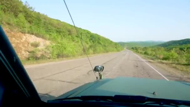 从汽车的前窗往外看 一辆绿色的大吉普车沿着一条风景秀丽的柏油路行驶 汽车旅游 — 图库视频影像