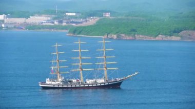 2020 yazında Rusya 'nın başkenti Vladivostok' ta bir eğitim gemisi Pallada, Russky Adası 'ndaki Uzak Doğu Federal Üniversitesi kampüsünün arka planında Doğu Boğazı' ndan geçiyor.