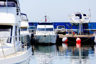 2016 yazı - Vladivostok, Primorsky bölgesi - yat kulübünde güzel yatlar ve tekneler var. Mavi gökyüzüne karşı kar beyazı yatlar.