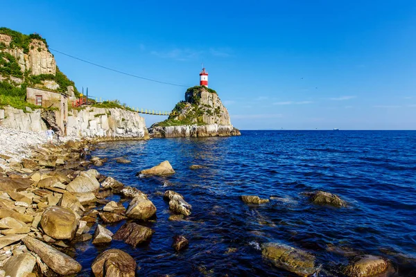 The most beautiful lighthouse in Vladivostok is the Basargin Lighthouse. Marine lighthouse in Vladivostok in summer against the background of the blue sea.