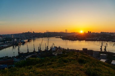 2020 yazında Vladivostok, Rusya Vladivostok 'ta şafak söktü. Golden Horn Körfezi ve Ticari Deniz Limanı 'nın havadan görünüşü. Kargo gemileri ticari limanın rıhtım duvarında duruyor..