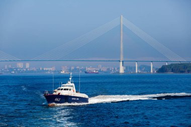 A Coast Guard boat goes at high speed through the water area of Vladivostok clipart