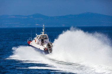 Bir sahil güvenlik botu Vladivostok 'un su alanından yüksek hızda geçer.