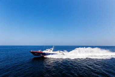 Bir sahil güvenlik botu Vladivostok 'un su alanından yüksek hızda geçer.