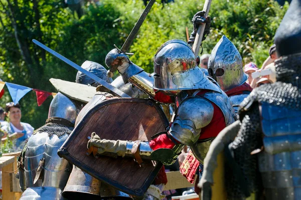 Knight Tournament. Medieval restorers fight with swords in armor at a knightly tournament