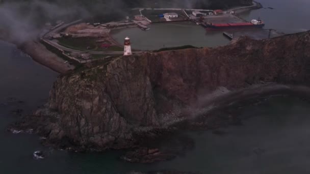 Vista desde arriba. Cabo Briner cubierto de niebla en el Territorio Primorsky. Faro Rudny en Cape Briner. — Vídeos de Stock