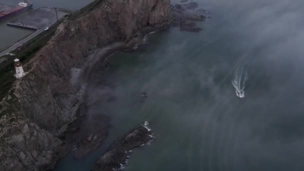 Blick von oben. Kap Briner im Primorsky Territory mit Nebel bedeckt. Leuchtturm Rudny am Kap Briner. — Stockvideo