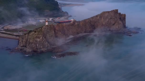 Vista desde arriba. Cabo Briner cubierto de niebla en el Territorio Primorsky. Faro Rudny en Cape Briner. — Vídeos de Stock