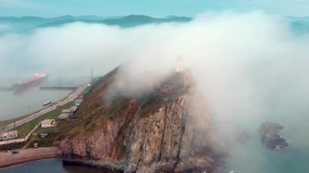 Vista desde arriba. Cabo Briner cubierto de niebla en el Territorio Primorsky. Faro Rudny en Cape Briner. — Vídeos de Stock