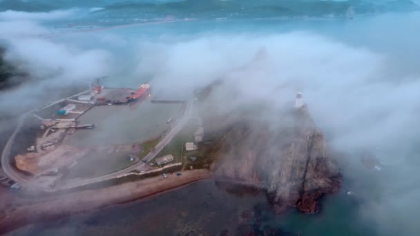 Θέα από ψηλά. Cape Briner καλύπτονται με ομίχλη στην περιοχή Primorsky. Φάρος Rudny στο Cape Briner. — Αρχείο Βίντεο