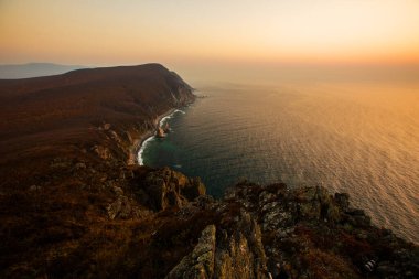 Sikhote-Alin Biosphere Reserve in the Primorsky Territory. Panoramic view of the rocky coastline of the nature reserve during pink sunrise clipart