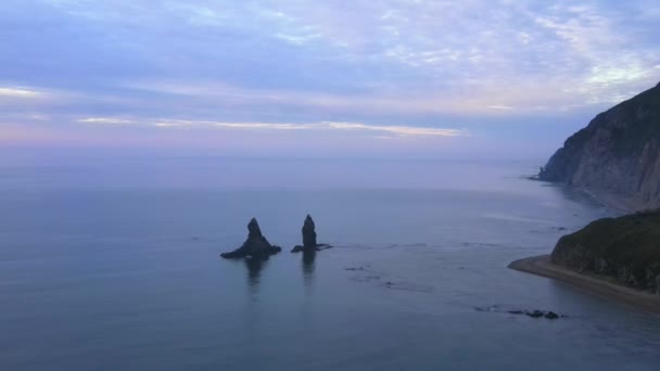 Vue d'en haut. Grand kekura Deux frères au milieu de la mer sur fond de montagnes vertes. — Video