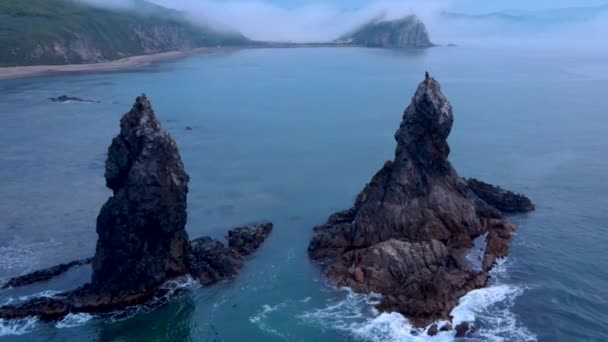 Blick von oben. Große Kekura Zwei Brüder mitten im Meer vor der Kulisse grüner Berge. — Stockvideo