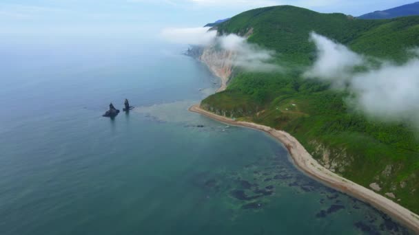 View from above. Large kekura Two brothers in the middle of the sea against the backdrop of green mountains. — Stock Video