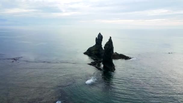 Вид сверху. Большой kekura Два брата в середине моря на фоне зеленых гор. — стоковое видео