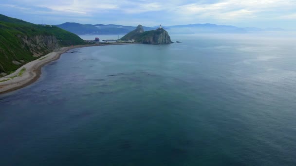 Blick von oben. Große Kekura Zwei Brüder mitten im Meer vor der Kulisse grüner Berge. — Stockvideo
