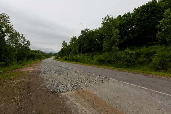 Très mauvaise route en Russie. La route asphaltée est tout dans les trous au milieu de la forêt. — Photo