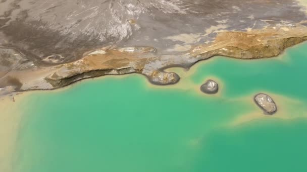 Вид сверху. Камера пролетает над химическим озером с бирюзовой водой. Хвостохранилище Хрустальненского ГОКа в Приморском крае — стоковое видео