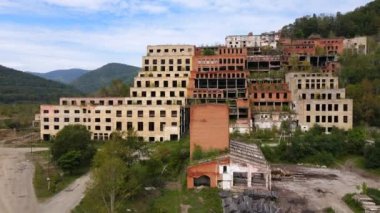 Yukarıdan bak. Kamera, Primorsky Bölgesi 'ndeki Khrustalny köyündeki Khrustalnensky madencilik ve işleme tesisinin terk edilmiş fabrikasının yanından geçiyor. Terk edilmiş teneke madencilik fabrikası