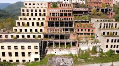 Yukarıdan bak. Kamera, Primorsky Bölgesi 'ndeki Khrustalny köyündeki Khrustalnensky madencilik ve işleme tesisinin terk edilmiş fabrikasının yanından geçiyor. Terk edilmiş teneke madencilik fabrikası