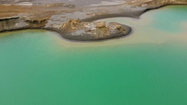 Kilátás fentről. A kamera egy türkiz vízzel teli kémiai tó felett repül. A hrustalnenskiji bányászati és feldolgozó üzem nyomvonala a Primorszkij területén — Stock videók