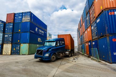 2016 yazı - Primorsky Krai, Rusya - konteyner terminali. Metal konteynırlar arasında giden konteynırlı bir kamyon.