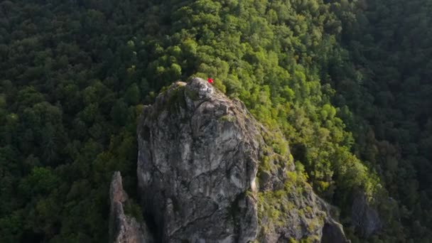 Outono, 2016 - Kavalerovo, Rússia - Vista superior. Uma bandeira vermelha flutua ao vento no topo do penhasco de Dersu, o suposto local de encontro de Dersu Uzala com o viajante russo Vladimir Arsenyev — Vídeo de Stock