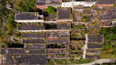 Yukarıdan bak. Khrustalnensky madencilik ve işleme tesisi. Kamera, büyük bir teneke madenciliğinin yıkılmış binalarının üzerine kaldırıldı.