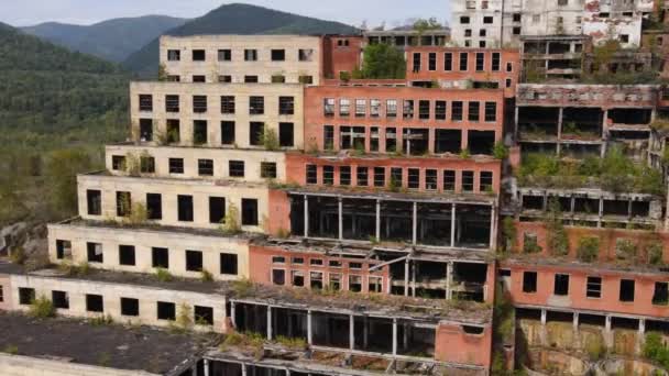 Vue d'en haut. Usine minière et de traitement Khrustalnensky. La caméra passe devant les bâtiments détruits d'une usine d'extraction d'étain en Russie. — Video