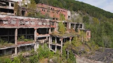 Yukarıdan bak. Khrustalnensky madencilik ve işleme tesisi. Kamera Rusya 'daki bir maden fabrikasının yıkılmış binalarının yanından uçuyor..