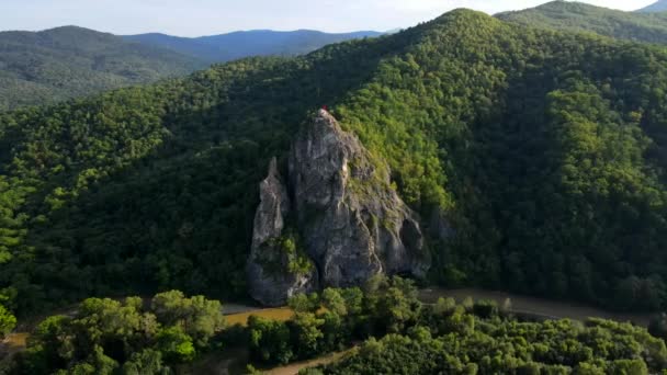 Pohled shora. Dersu rock ve vesnici Kavalerovo. Velká skála na pozadí kopců se zeleným lesem. Jednopodlažní vesnické domy na pozadí zelených hor a skal — Stock video